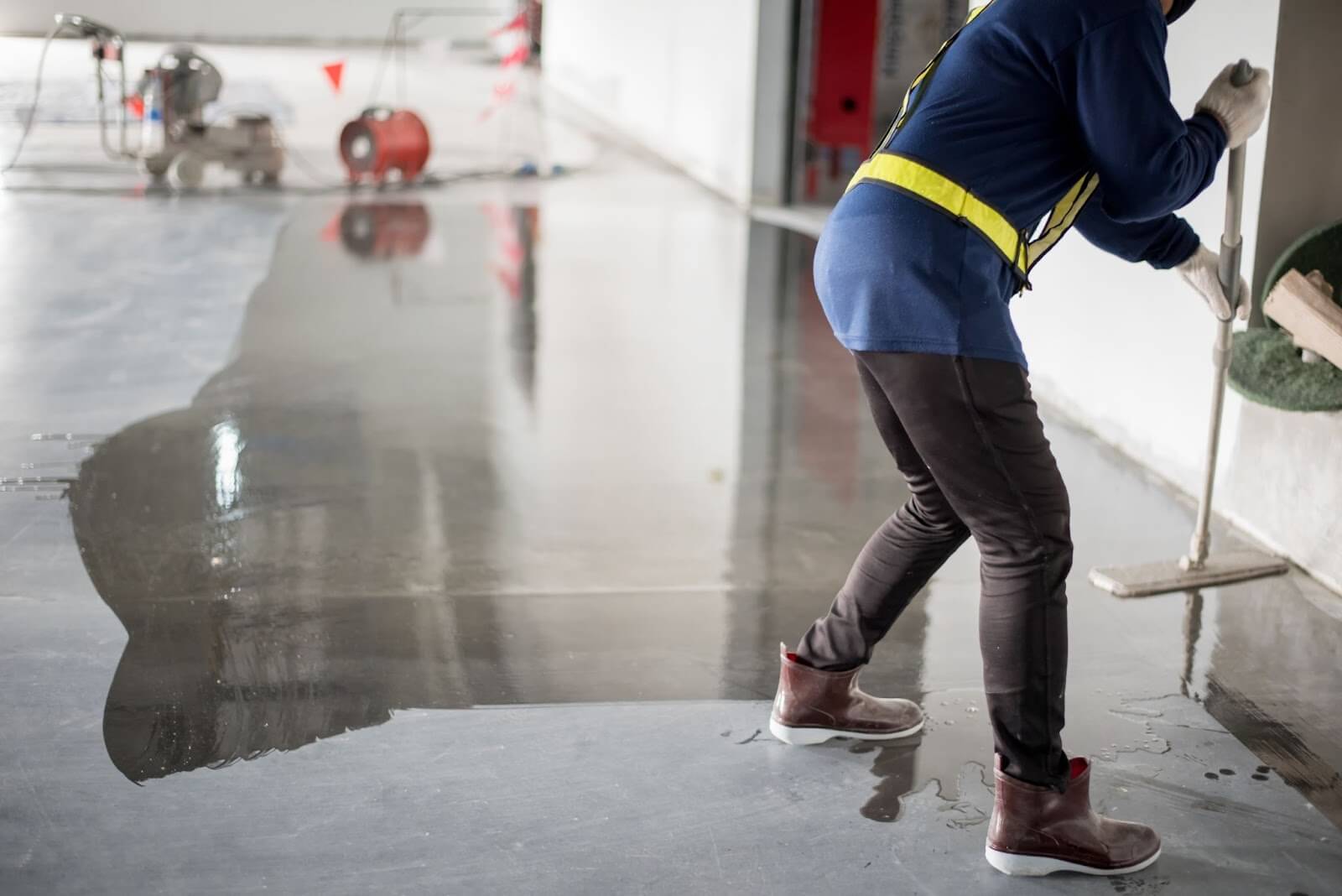 Worker applying epoxy to commercial concrete flooring